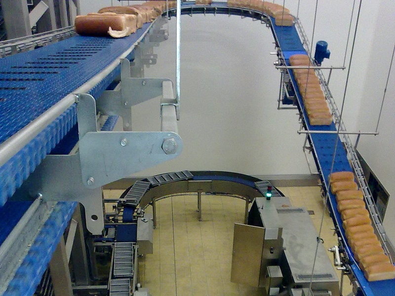 We are active in Bakeries, bread and sugar goods, meat processing, dairy industry, fresh produce. 
							On the photo a part of a complete automation of a transport system with a loop with machines in an industrial bakery in the Netherlands. Baking trays are being filled wth dough, then moving into 
							a Proofer, and then to the oven, and when the trays left the oven, the breads will be depanned and transported to the packing area. The empty baking trays moves towards a buffer repository and are 
							ready to go to the beginning of the production line. This type of systems are world wide implemented.